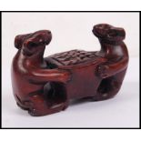 An Oriental carved novelty figure of two mice carrying a box.