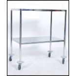 A vintage 20th century retro industrial medical dentist trolley of chrome construction raised on