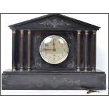 An early 20th century black marble slate mantel clock, raised on a block plinth with columned
