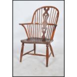 An 18th / 19th Century elm and yew Windsor farmhouse elbow chair. The arched stick back with a