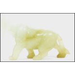 An Oriental Chinese jade carving of a dog / temple lion with open jaw and hanging tongue.