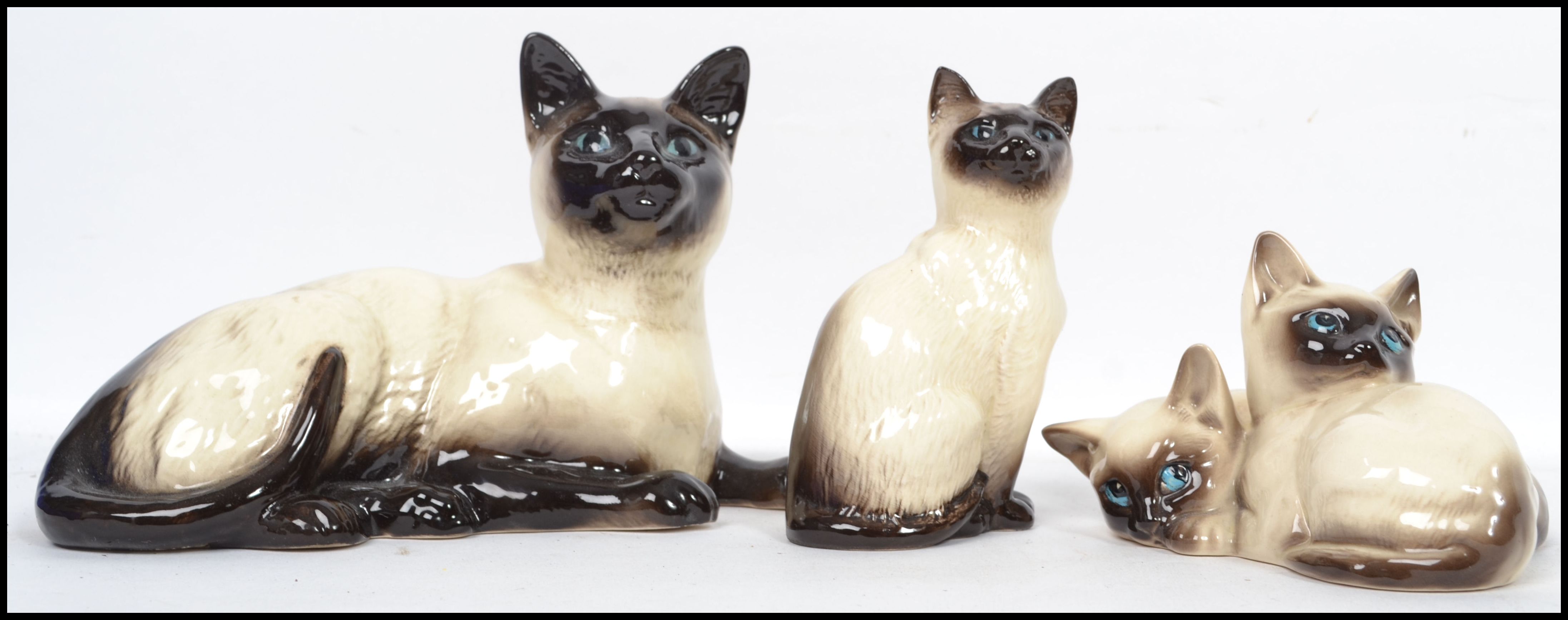 A group of vintage ceramic cats to include a Royal Doulton 1296 a Beswick 1887 and a Beswick 1559.