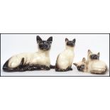 A group of vintage ceramic cats to include a Royal Doulton 1296 a Beswick 1887 and a Beswick 1559.