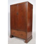 An early 20th century oak bachelors wardrobe combination having double doors being mid height with