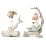 A pair of Lladro ceramic figurines of a male and female cherub mounted on a log with large ceramic