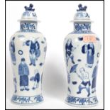 A pair of Oriental Chinese blue and white vases with lids having bands of floral decoration and