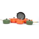 A collection of vintage 20th century kitchenalia Le Cruset frying pans an cooking points in orange
