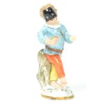 A 18th century Meissen ceramic Masquerade figurine of a boy with mask raised on a circular