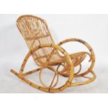 A vintage 20th century retro designer bamboo rocking chair of unusual form in the manner of Louis