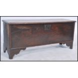 An 18th century joined elm country coffer chest having a wide carved panelled front being raised