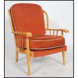 A 1970's retro Ercol style armchair of beech wood construction being raised on turned legs having