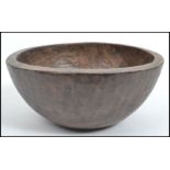 An Indian wooden bowl having an adds carved snakeskin design with flat base. Measures 16 cm high and