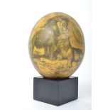 A Victorian style painted ostrich egg having a yellow ground depicting scenes of lions, ostrich,