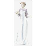 A Lladro ceramic figurine entitled ' Winter Love  ' depicting a lady in dress holding a platter of