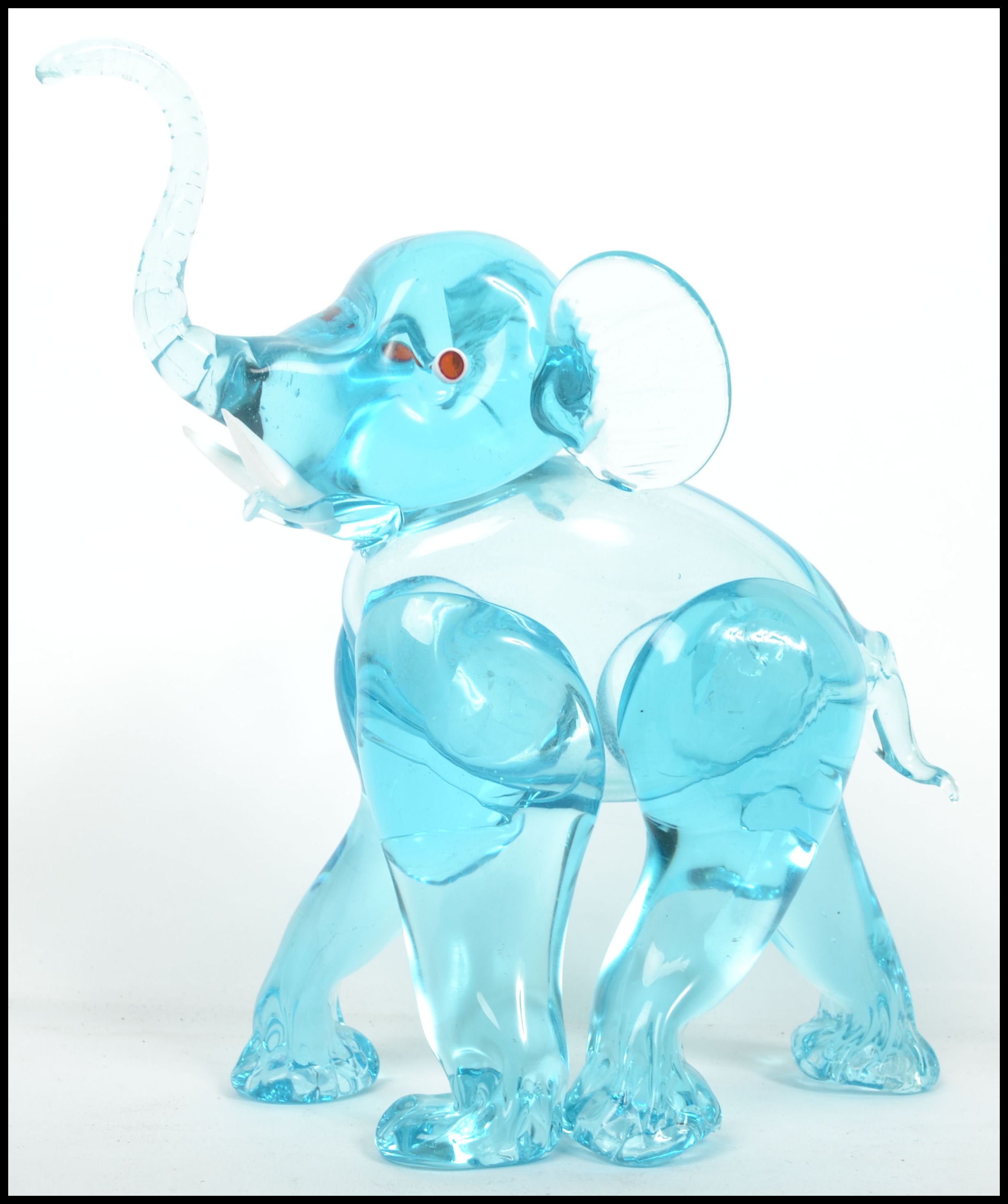 An unusual 20th century / 1960's retro glass elephant figurine. Blue glass with colourful eyes and