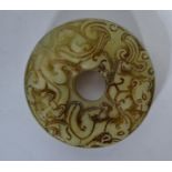 An Oriental jade carved bi of roundel form with ho