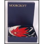 A Moorcroft ceramic tube lined pin dish coaster decorated in the Scarlet pattern with impressed