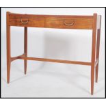 A mid century teak and mahogany writing table desk having chamfered edge squared legs united by