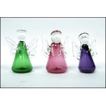 A group of three Bristol Blue Glass angels in peridot, amethyst and cranberry colour ways complete