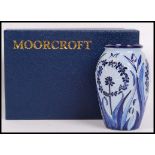 A Moorcroft pottery vase tube lined decorated in the Leila pattern on a blue ground, impressed