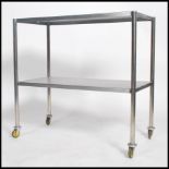 An original mid century Industrial surgeons theatre trolley of tubular metal and stainless steel