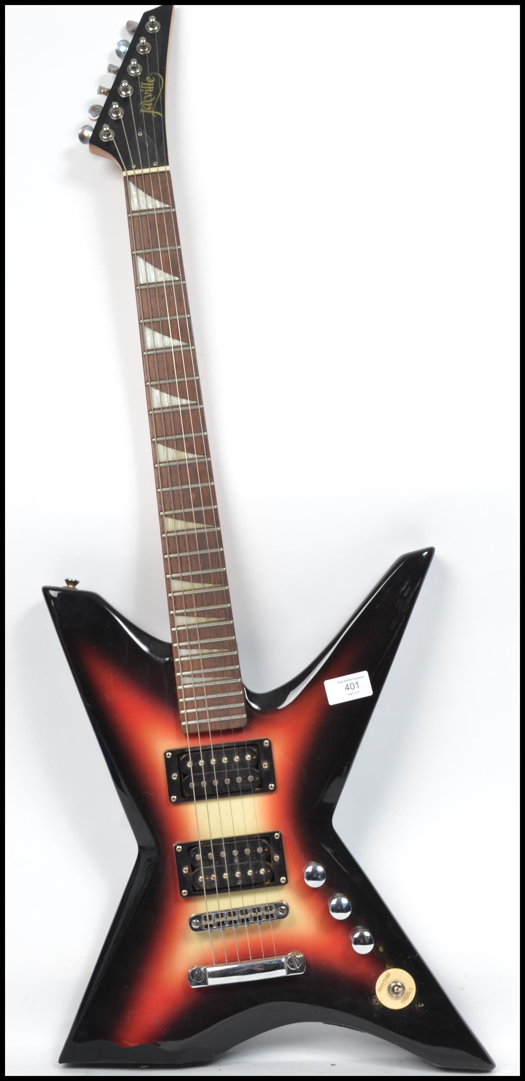 A vintage Jaxville six string electric guitar musical instrument having an X shaped body with burned