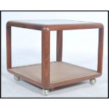 A vintage retro 20th century teak wood G-Plan square coffee table having a glass insert raised on