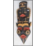 A 20th century large African tribal art wall mask of colourful decorative elongated form having twin