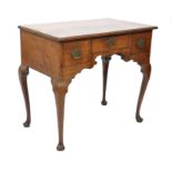A 19th century oak lowboy desk being raised on splayed cabriole legs with three drawers, a short