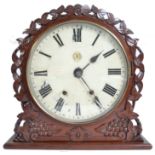 A GWR railway station clock set within a mahogany frame with flower head borders to the circular