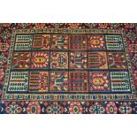 An early 20th century Persian carpet hand woven floor rug having a blue and red ground. The