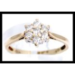 A hallmarked 9ct gold and diamond cluster ring. Ha