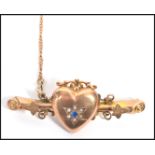 A hallmarked 9ct gold bar brooch having a heart lo