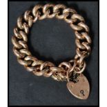 A hallmarked 9ct gold large heavy heart lock bracelet chain with engraved design. Weighs 39.5