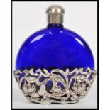 A silver and blue glass ladies perfume bottle flask. Of moon shaped form with pierced silver