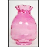 A 19th century large oversized cranberry glass oil lamp shade of pimple form with handkerchief