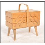 A vintage retro 20th century beechwood metamorphic sewing box raised on angular legs with opening