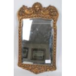 A 19th century Victorian mirror having an inset bevelled glass panel with a carved and moulded