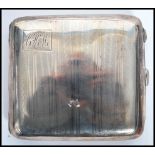 A silver hallmarked cigarette case with engine turned decoration, monogram cartouche to corner.