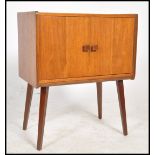 A vintage 20th century  retro teak wood media cabinet raised on sputnik legs with vinyl record