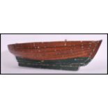 A vintage 20th century painted wood hull model of a clinker - built rowing boat, riveted detail