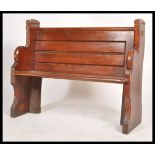 A 20th century antique style pine pew of small form with bench seat, panelled back rest and with
