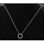 A 14ct gold and diamond pendant necklace strung with a diamond set halo on a white gold fancy link