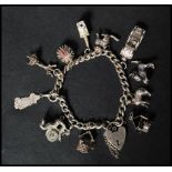 A hallmarked silver heart padlock clasp charm bracelet with many charms to include hedgehog cat