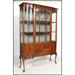 An Edwardian mahogany inlaid large inlaid serpentine fronted display cabinet. Raised on cabriole