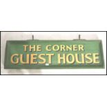 A retro mid century wooden painted advertising sign being double sided with green ground and