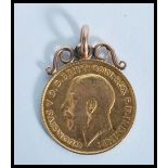 A gold 1914 George V half Sovereign with mounted scroll work gold  mount total gross weight 4.5g
