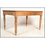 A Victorian pine country dining table being raised on turned legs with fitted frieze having single