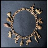 A hallmarked 9ct gold charm figaro link bracelet chain having a lobster claw clasp. Charms to
