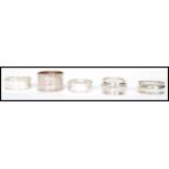 A collection of five silver hallmarked non - matching napkin rings in various shaped and styles